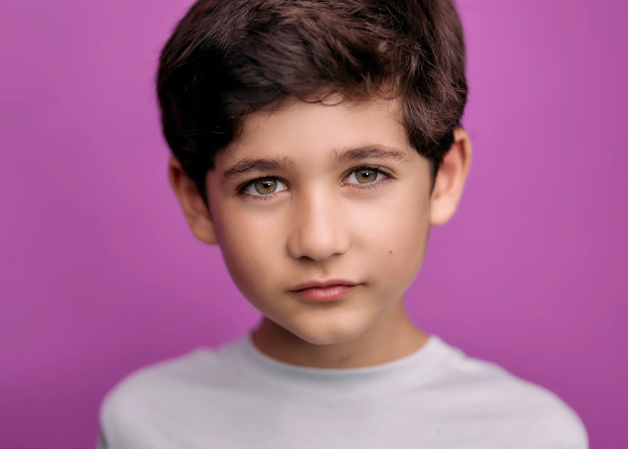 Young boy on a bold pink seamless backdrop